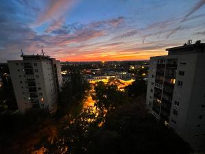 a view of a city at sunset with buildings at Monos Apartman in Tatabánya