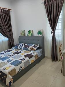 una camera da letto con un letto e un copriletto con animali di Ann_HomeStay a Sandakan