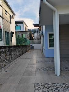 einen Gehweg außerhalb eines Hauses mit einem Gebäude in der Unterkunft Ann_HomeStay in Sandakan