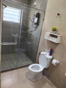 a bathroom with a toilet and a shower with a glass door at Ann_HomeStay in Sandakan