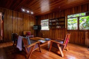 een eetkamer met een tafel en stoelen en een tv bij Forest Garden House in Monteverde Costa Rica