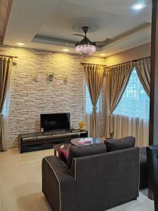 un soggiorno con divano e TV di Ann_HomeStay a Sandakan