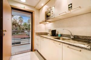 a kitchen with a sink and a sliding glass door at Dfm Happy Days D - Funchal in Funchal