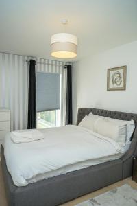 a large bed in a bedroom with a window at DARTFORD LUXURY 2 BED APARTMENT in Kent