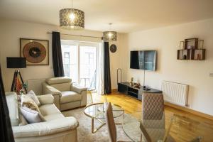 a living room with a couch and chairs and a table at DARTFORD LUXURY 2 BED APARTMENT in Kent