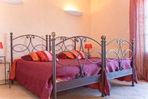 een slaapkamer met een bed met paarse en oranje kussens bij Campu Latinu in Lama