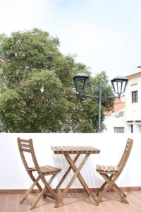 a picnic table and two chairs on a patio at Sudoeste Guest House in Odeceixe