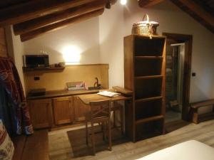 cocina con encimera, mesa y estantería en BAITA Ancienne Bergerie, en Valtournenche