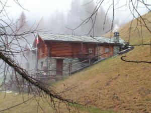 una cabaña de madera a un lado de una colina en BAITA Ancienne Bergerie, en Valtournenche