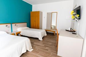 ein Hotelzimmer mit 2 Betten und einem TV in der Unterkunft Spira Mirabilis Napoli in Neapel