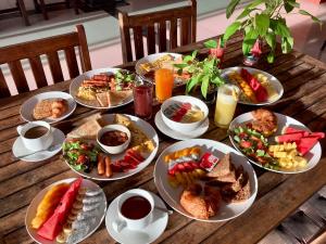 a wooden table with plates of food on it at Lanta Just Come Hotel in Ko Lanta