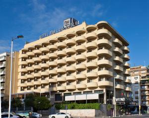 um edifício de hotel com uma placa em cima em NH Luz Huelva em Huelva