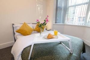 un tavolo bianco con un piatto di cibo su un letto di Room for All Your 4-Bedroom Comfort Zone a Leicester