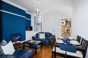 a living room with a blue accent wall at Room for All Your 4-Bedroom Comfort Zone in Leicester