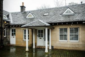 a brick house with white doors and a roof at Tower Square House in Alloa