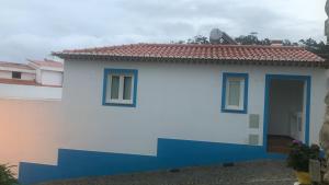 a white and blue house with a red roof at Sudoeste Guest House in Odeceixe