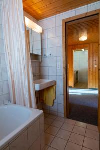 a bathroom with a tub and a sink and a mirror at Chalet Weisshorn 4 in Bettmeralp