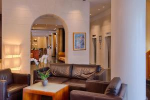 西恩納的住宿－NH錫耶納酒店，客厅配有真皮沙发和桌子