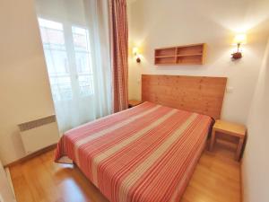 - une petite chambre avec un lit et une couverture rayée dans l'établissement Ostal, T3, centre Luchon, wifi, casier à skis, ascenseur, 6 personnes, à Luchon