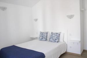 a bedroom with a bed with two pillows on it at Sudoeste Guest House in Odeceixe
