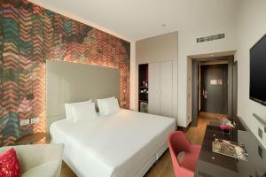 a hotel room with a bed and a couch at NH Collection Milano President in Milan