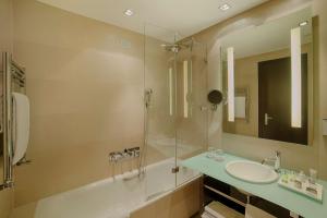 a bathroom with two sinks and a glass shower at NH Collection Milano President in Milan