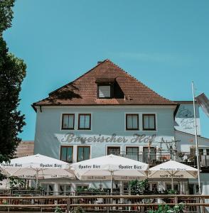 ein großes weißes Gebäude mit Sonnenschirmen davor in der Unterkunft Bayerischer Hof Spalt in Spalt