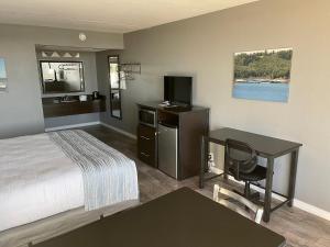 a hotel room with a bed and a desk and a television at Lake Norfork Resort in Henderson