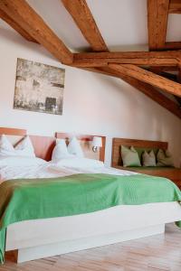 a bedroom with a large bed with a green blanket at Bayerischer Hof Spalt in Spalt