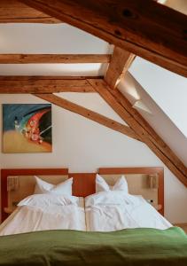 2 Betten in einem Schlafzimmer mit Holzdecken in der Unterkunft Bayerischer Hof Spalt in Spalt