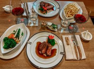 a wooden table with plates of food on it at Bayerischer Hof Spalt in Spalt