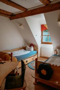 a attic room with two beds and a table at Bayerischer Hof Spalt in Spalt