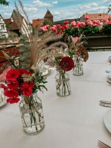 three vases filled with flowers on a table at Bayerischer Hof Spalt in Spalt