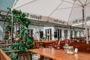 a restaurant with wooden tables and chairs and plants at Bayerischer Hof Spalt in Spalt