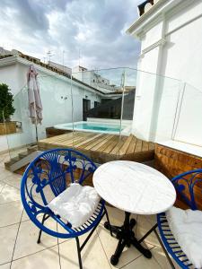 a patio with a table and chairs on a balcony at Casa Bailen Sevilla in Seville
