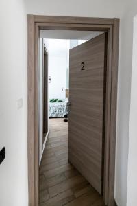 eine Holztür, die zu einem Flur mit einem Schlafzimmer führt in der Unterkunft Spira Mirabilis Napoli in Neapel