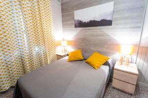 a bedroom with a bed with yellow pillows and two lamps at Gran Duc Pedrous in Pas de la Casa