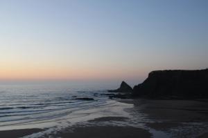 a view of the beach at sunset at Sudoeste Guest House in Odeceixe