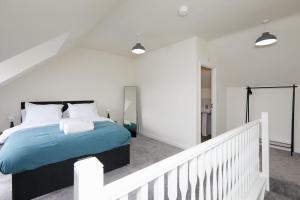 a bedroom with a large bed and a staircase at Urban Bliss, Park with Ease 3 Bed New Build Home in Leicester