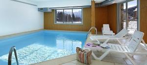 a swimming pool with two lounge chairs and a table at Chez Lulilo in Ax-les-Thermes