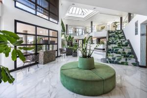 a lobby with a green ottoman in the middle at Occidental Roca Negra - Adults Only in Agaete
