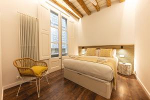 a bedroom with a bed and a chair at Bravissimo Ferreries, 3-bedroom apartment in Girona
