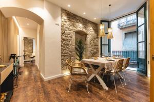 una sala da pranzo con parete in pietra, tavolo e sedie di Bravissimo Ferreries, 3-bedroom apartment a Girona
