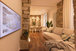 sala de estar con sofá y pared de piedra en Bravissimo Ferreries, 3-bedroom apartment, en Girona