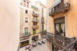 un apartamento con balcón con mesas y sillas en un edificio en Bravissimo Ferreries, 3-bedroom apartment, en Girona