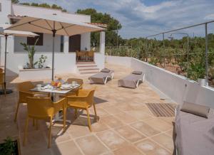 a patio with a table and chairs and an umbrella at Stella Maris - Formentera Break in Playa Migjorn