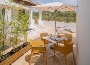 a patio with a table and chairs and an umbrella at Stella Maris - Formentera Break in Playa Migjorn