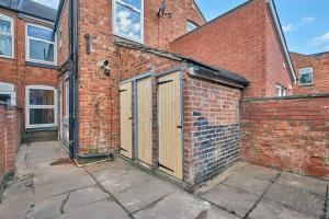 a brick building with two doors on the side of it at Sleek & Stylish Modern 4-Bedroom Urban Retreat in Leicester