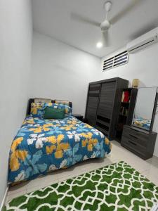 um quarto com uma cama e um tapete no chão em Homestay Kemaman Fyna06 em Kampong Kemaman