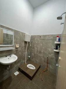 La salle de bains est pourvue de toilettes et d'un lavabo. dans l'établissement Homestay Kemaman Fyna06, à Kampong Kemaman